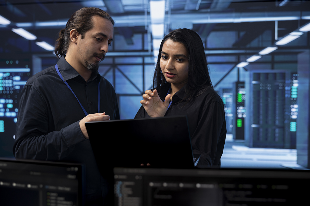 Two IT technicians work to solve a problem