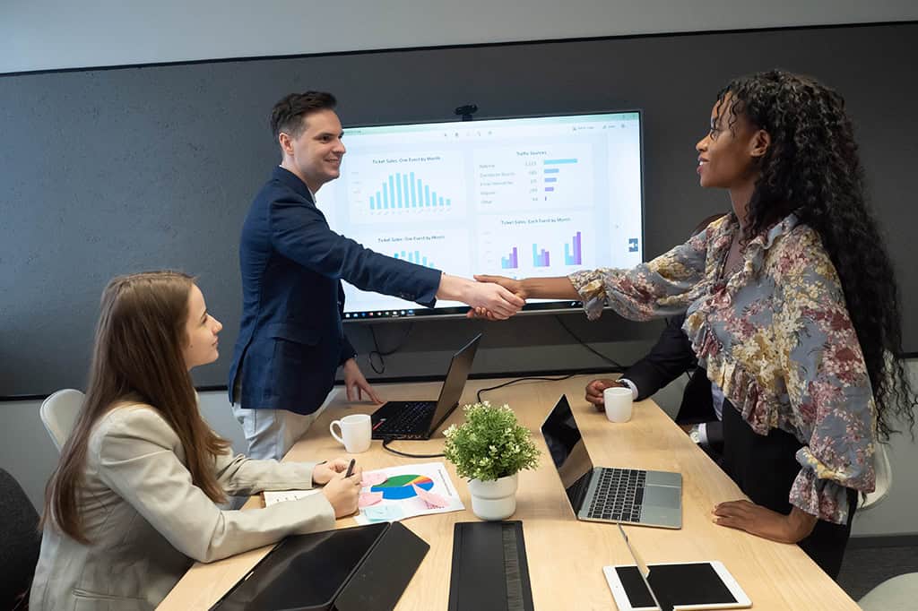 A board member at a nonprofit welcomes a new hire surfaced by data-driven hiring.