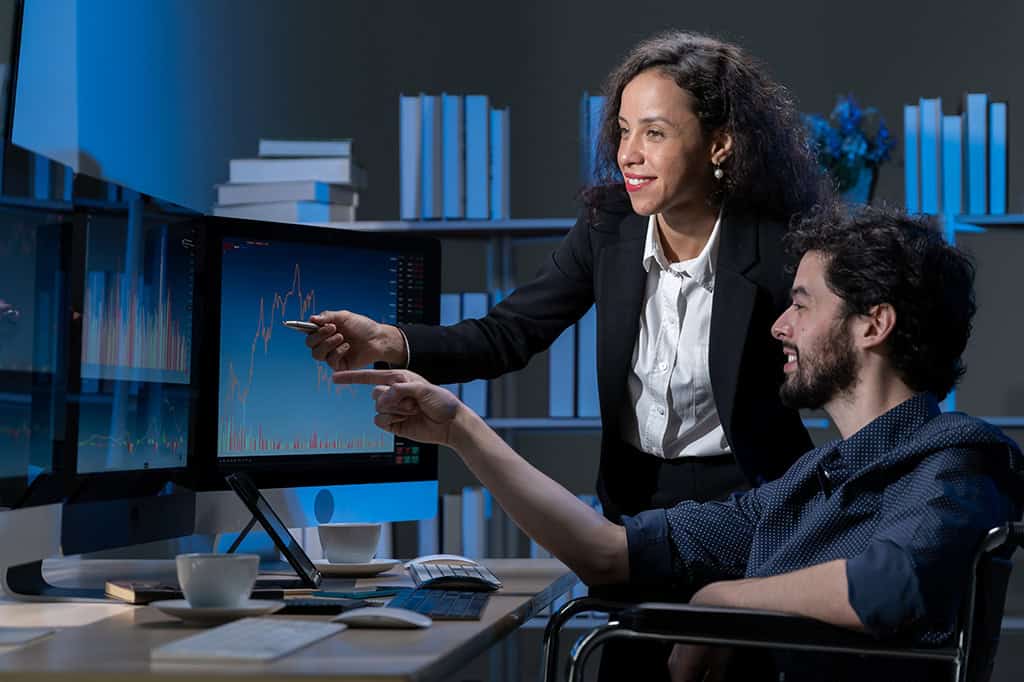 An IT support specialist shows someone how to navigate a report