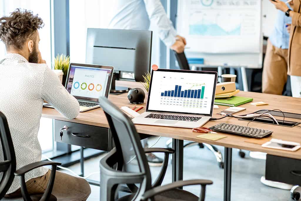 Computers showing analytics and financial reports in an office