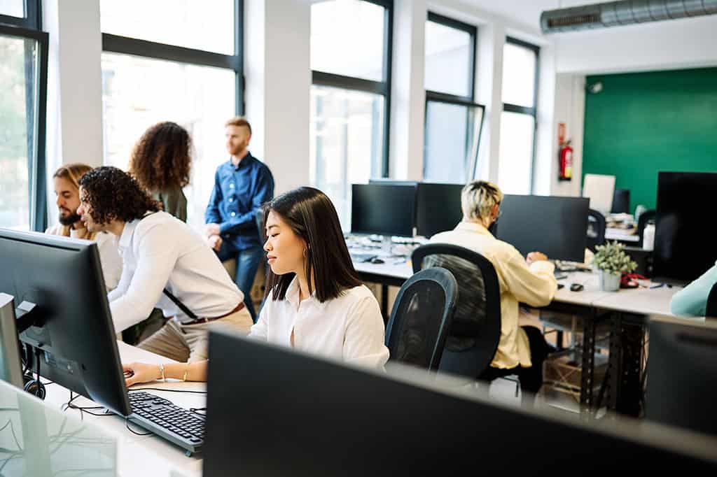 Focused office workers work in an open-concept office Focused office workers work in an open-concept office