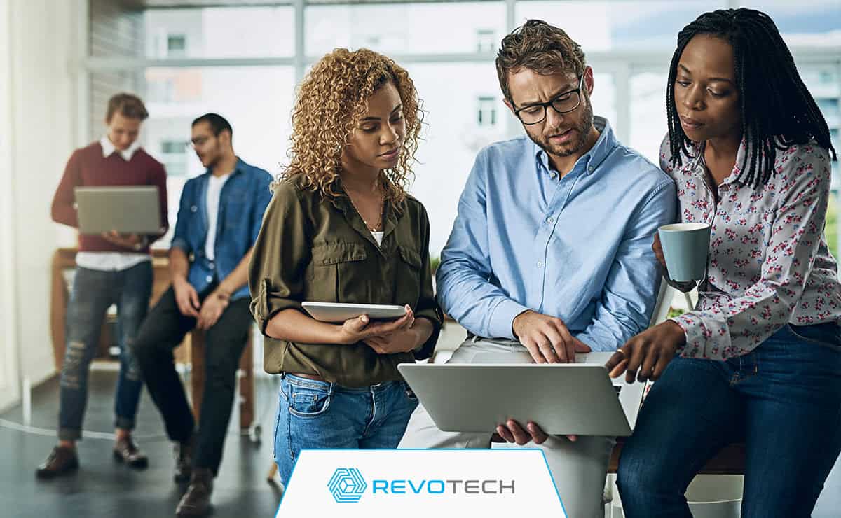 Group of non profit workers looking at laptop trying to solve IT issue