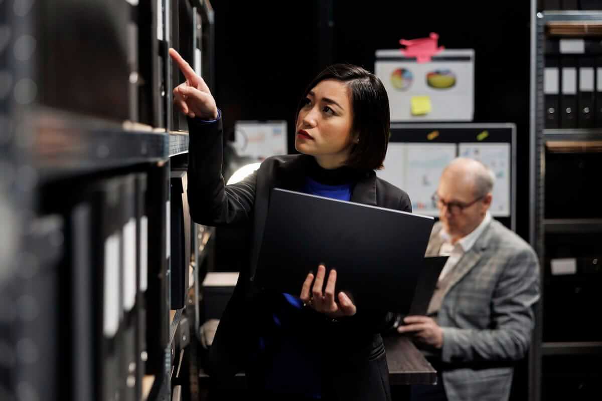 IT manager with laptop in server room attempting to restore data from backup after breach