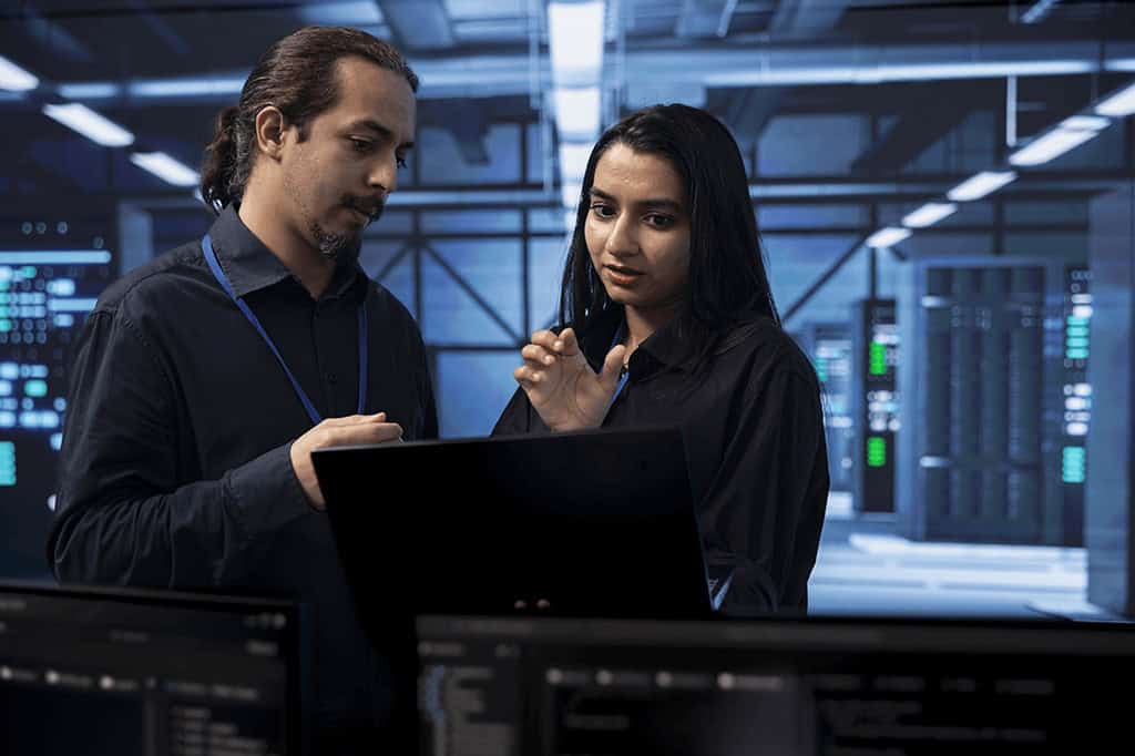 Two IT technicians work to solve a problem